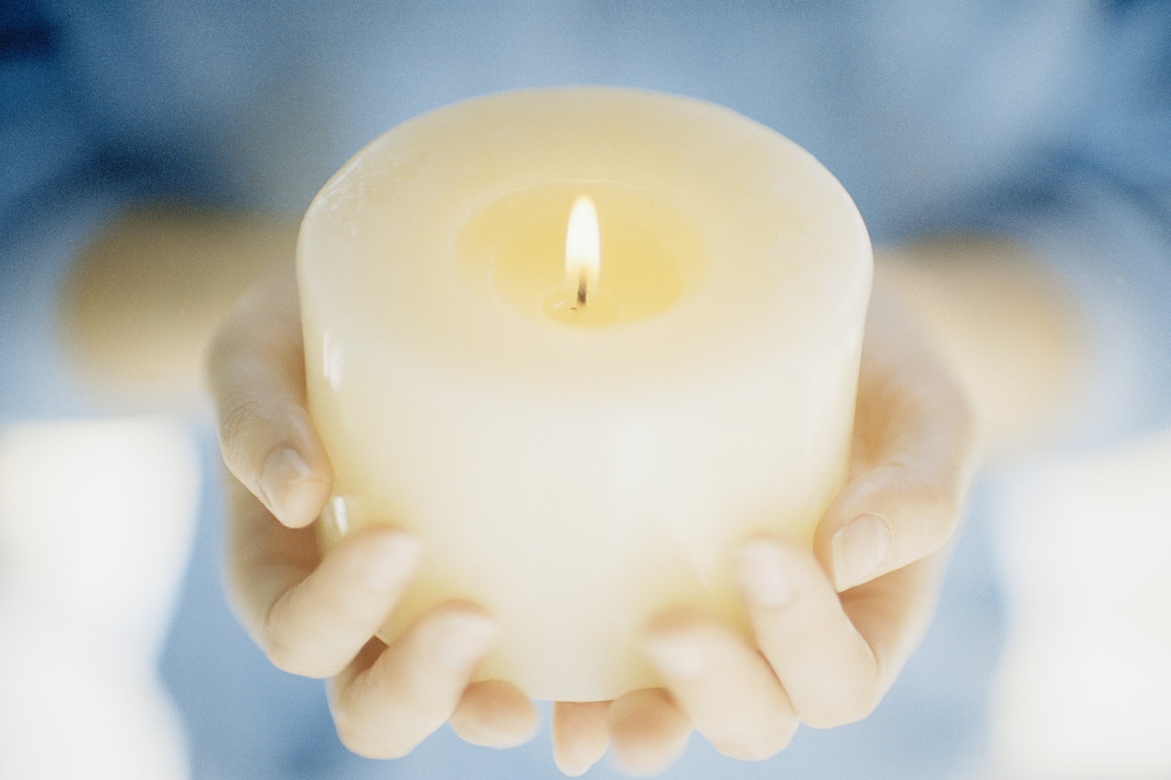 Hands Holding a Lit Candle