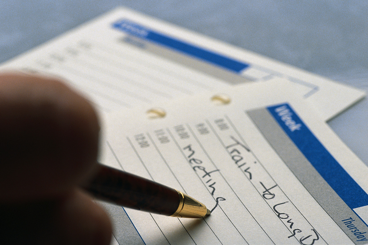 photo of someone writing on a calendar